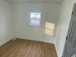 Unfurnished room with wood finished floors and baseboards