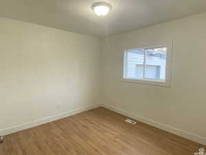 Unfurnished room featuring baseboards and light wood finished floors