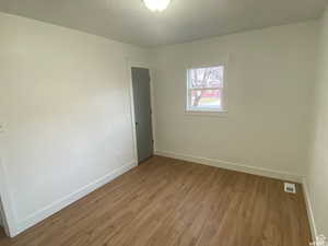 Unfurnished room with wood finished floors and baseboards