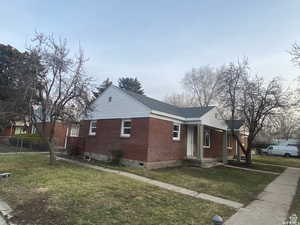 View of side of property with brick siding and roof with shingles