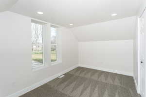 Bonus room featuring lofted ceiling, dark colored carpet, and recessed lighting