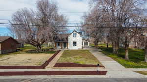 Traditional home featuring a porch, concrete driveway, a front lawn, and stucco siding