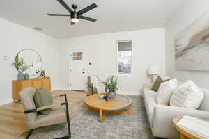 Living room with a ceiling fan and light wood-style floors