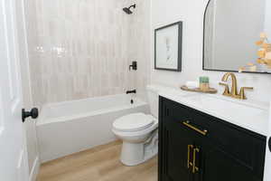 Full bath with vanity, light wood-type flooring, and bathtub / shower combination