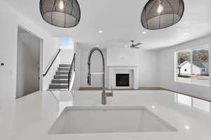 Kitchen featuring a fireplace, healthy amount of natural light, light stone counters, open floor plan, and recessed lighting
