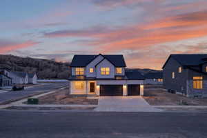 Modern inspired farmhouse with concrete driveway, board and batten siding, and an attached garage