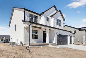 Modern farmhouse with covered porch, board and batten siding, and driveway
