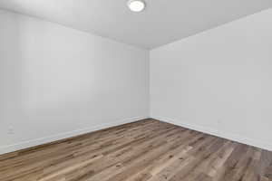 Spare room featuring wood finished floors and baseboards