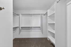 Walk in closet featuring dark carpet