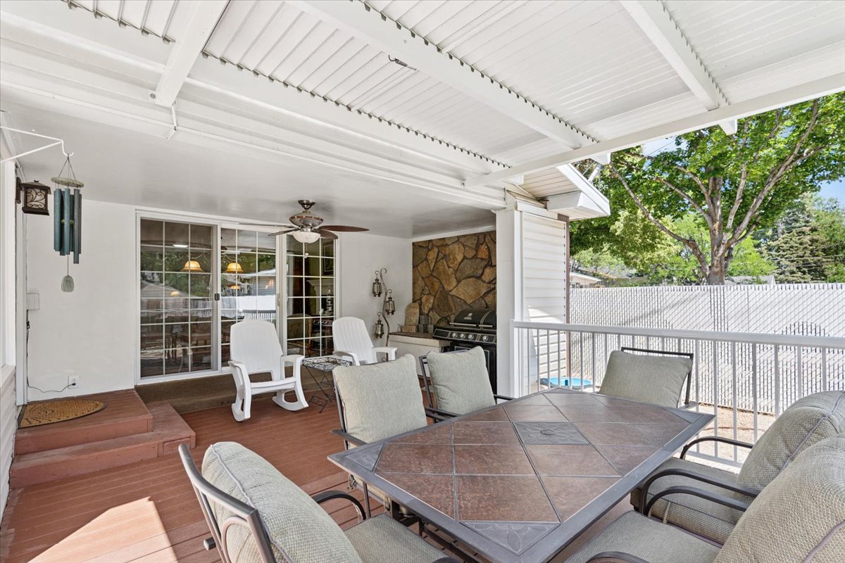 View of patio featuring outdoor dining area, a ceiling fan, a deck, and area for grilling