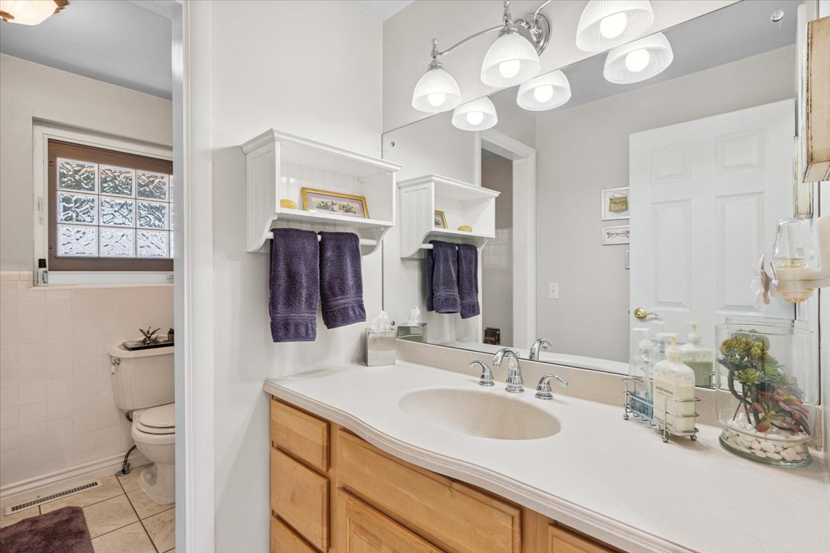 Bathroom with vanity, light tile patterned flooring, and tile walls