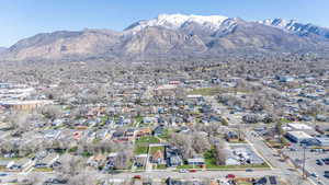 Aerial view of property and surrounding area featuring a mountainous background and nearby suburban area