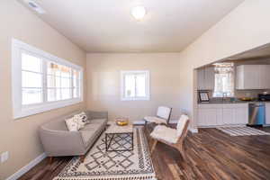 Living area featuring dark wood-type flooring and baseboards