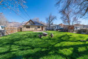 Rear view of property featuring solar panels and a fenced backyard