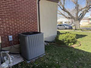 Exterior view of a central AC unit and brick siding