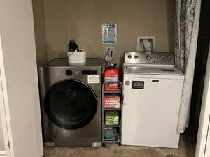 Laundry room featuring concrete flooring and washing machine and dryer