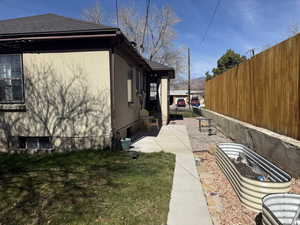 View of side of home featuring a shingled roof and stucco siding