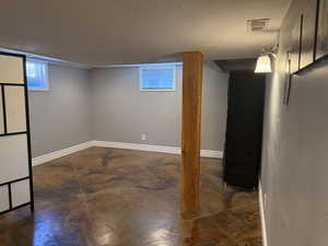 Below grade area featuring a textured ceiling and baseboards