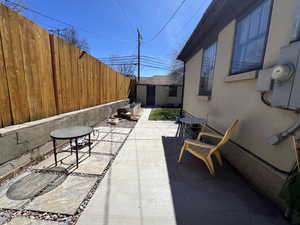 Fenced backyard featuring a patio and a storage shed