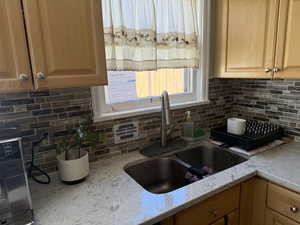 Kitchen featuring light stone counters and decorative backsplash