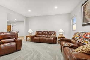 Living area featuring light colored carpet and recessed lighting