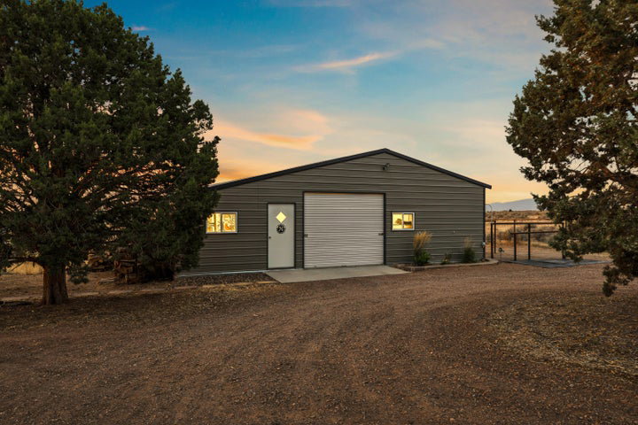 Detached garage with dirt driveway