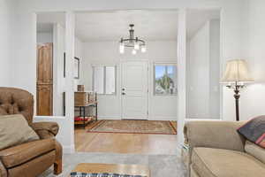 Entrance foyer with light wood-type flooring and suspended lighting