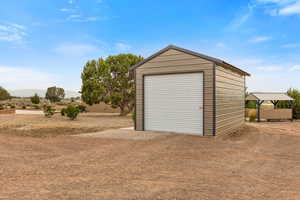 Detached garage featuring dirt driveway