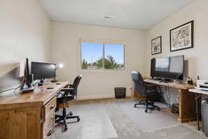 Home office with light carpet and baseboards