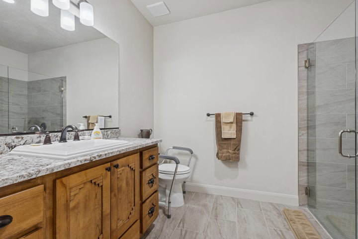 Full bath with a shower stall and vanity