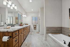 Bathroom with double vanity, a garden tub, a shower stall, and recessed lighting