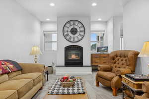 Living area with a warm lit fireplace and recessed lighting