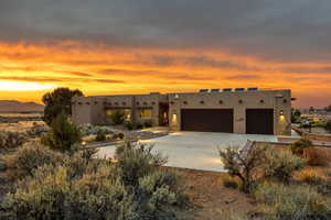Southwest-style home with a garage, stucco siding, and driveway