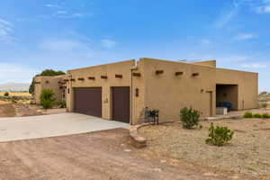 View of front of property featuring concrete driveway, stucco siding, and an attached garage