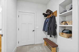 Mudroom with light colored carpet and baseboards