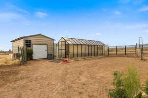 View of yard with an outbuilding and a greenhouse