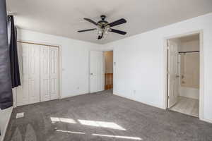 Unfurnished bedroom with light colored carpet, ceiling fan, ensuite bath, and a closet