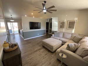 Living room with dark wood finished floors and ceiling fan
