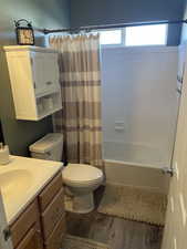 Full bath with vanity, dark wood-style floors, and shower / bath combination with curtain