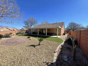 Back of house featuring a patio, a fenced backyard, a tiled roof, and stucco siding