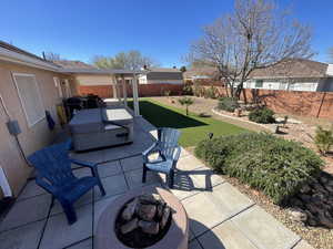 Fenced backyard with an outdoor fire pit, a patio area, and a residential view