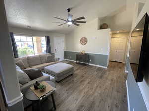 Living room featuring dark wood-style floors and a ceiling fan
