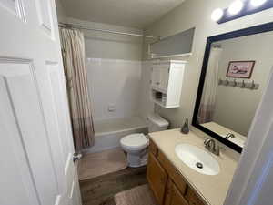 Bathroom with vanity, dark wood-type flooring, and shower / tub combo