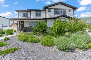 View of front of property featuring covered porch and brick siding