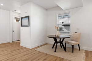 Dining space with light wood-style flooring and baseboards