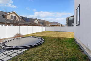 Fenced backyard with a trampoline