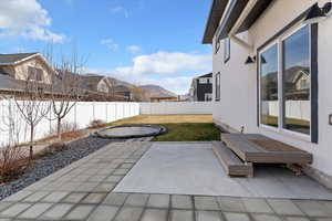 Fenced backyard featuring a patio area and a residential view