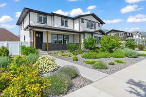View of front of house with a porch, brick siding, and a gate