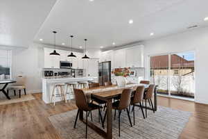 Dining area with light wood-type flooring and recessed lighting