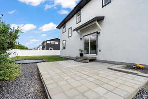 Rear view of property with a patio, a fenced backyard, and stucco siding
